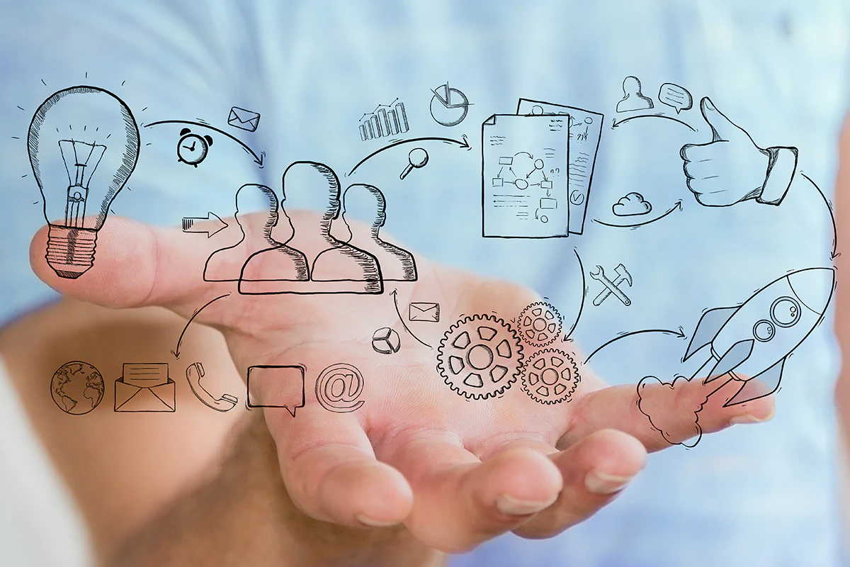 Photo: sdecoret / stock.adobe.com Eine Person hält eine Hand mit einer Zeichnung eines Geschäftssymbols, das Kreativität und Unternehmertum symbolisiert.